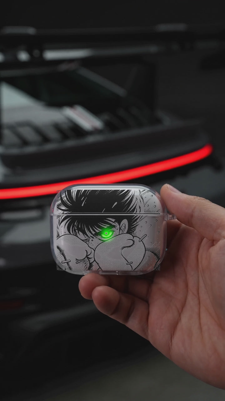 Boxer Eye AirPods case opening in hand with Porsche background